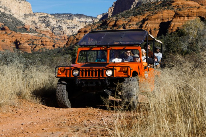 orange hummer full of people in the red rocks of sedona az